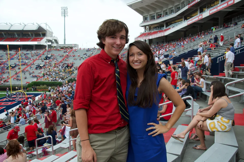 A couple smiling in the stands of a football stadium
